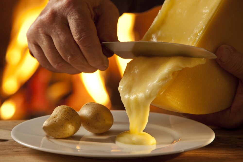 Raclette – phô mai nóng chảy đặc trưng của Thụy Sĩ, ăn kèm khoai tây và dưa muối