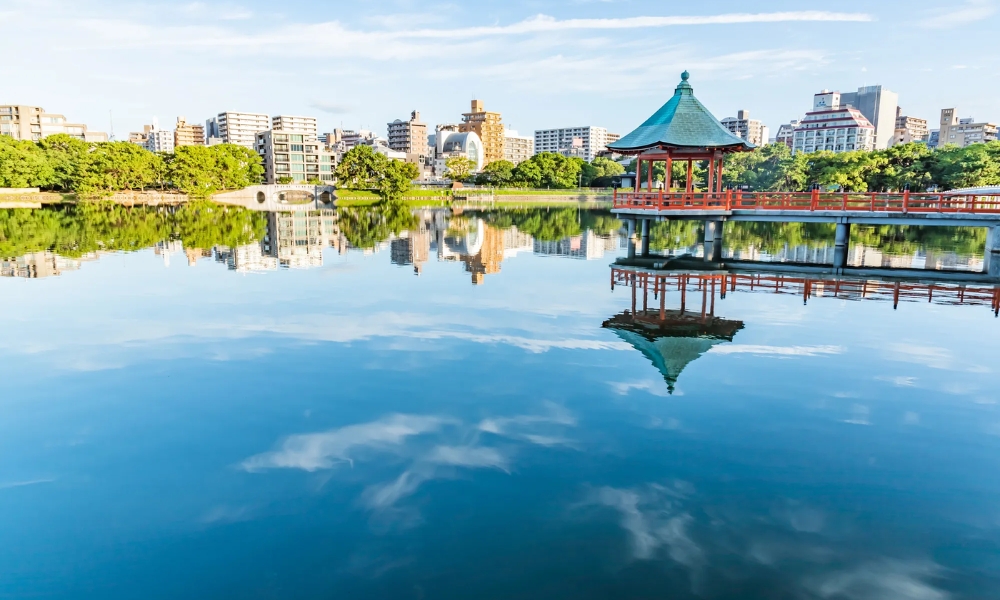 Hồ nước F168nhacai đón tết bính ngọ 2026 Ohori trong xanh phản chiếu bầu trời v&agrave; th&agrave;nh phố hiện đại Hakata.