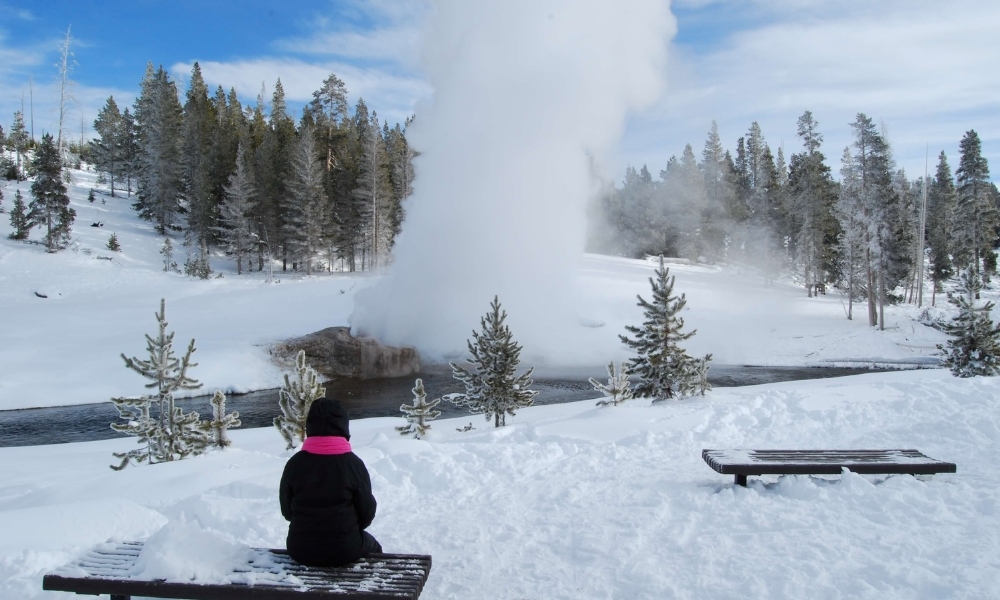 Hơi nước từ Old Faithful bốc lên giữa nền tuyết trắng tại Yellowstone mùa đông