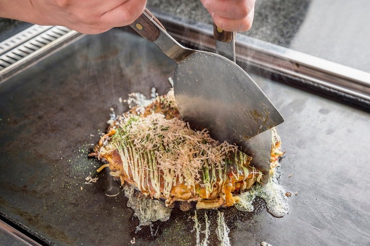 B&aacute;nh x&egrave;o Osaka Okonomiyaki được chế biến đơn giản bằng c&aacute;ch trộn lẫn c&aacute;c thứ với bột rồi đem chi&ecirc;n